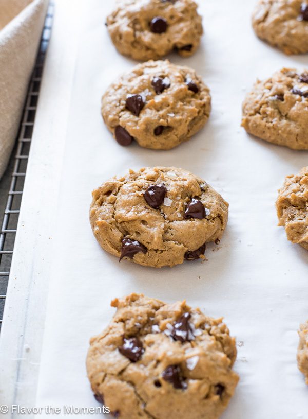 Flourless peanut butter chocolate chip oatmeal cookies on parchment lined baking sheet