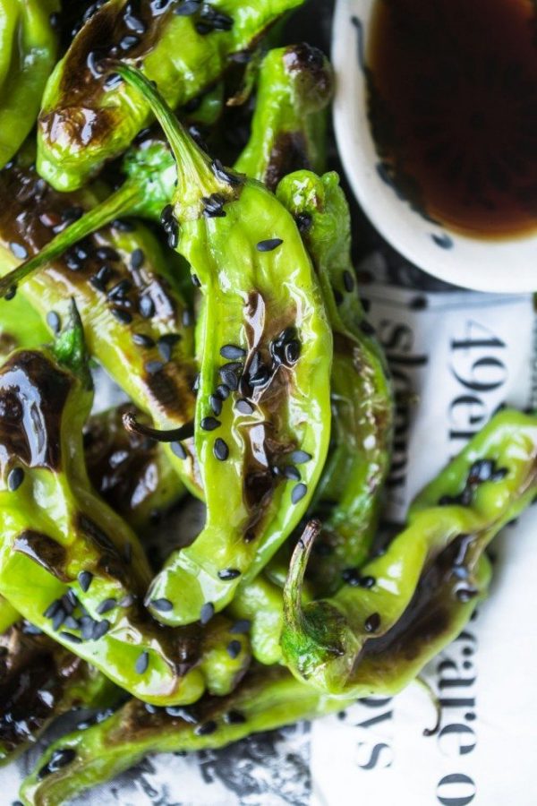 Grilled shishito peppers topped with black sesame seeds.