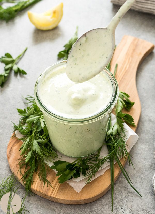 Greek yogurt ranch dressing in a jar on a wooden board