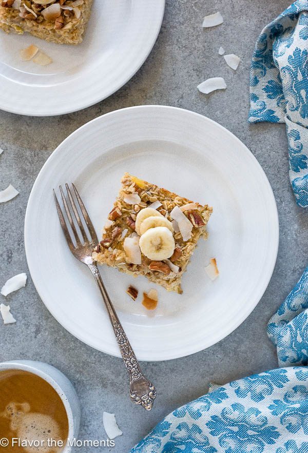 Serving of hummingbird cake baked oatmeal on plate with bananas and coconut