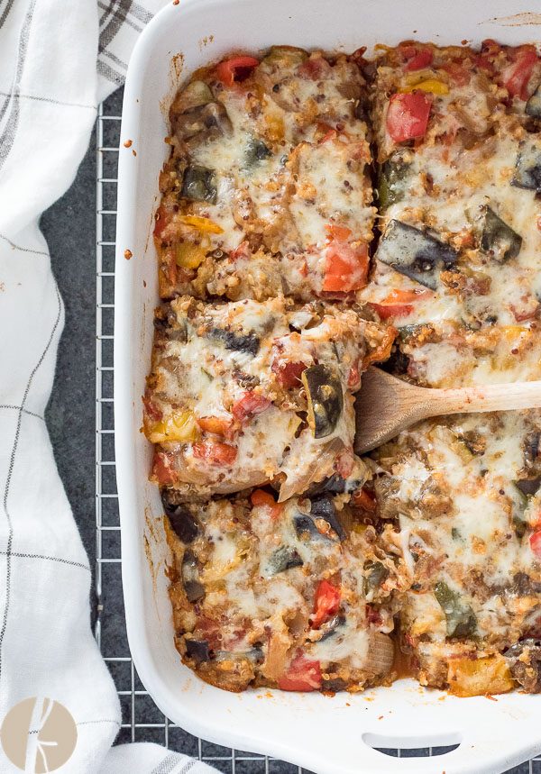 overhead shot of spatula with square of ratatouille casserole in a baking dish