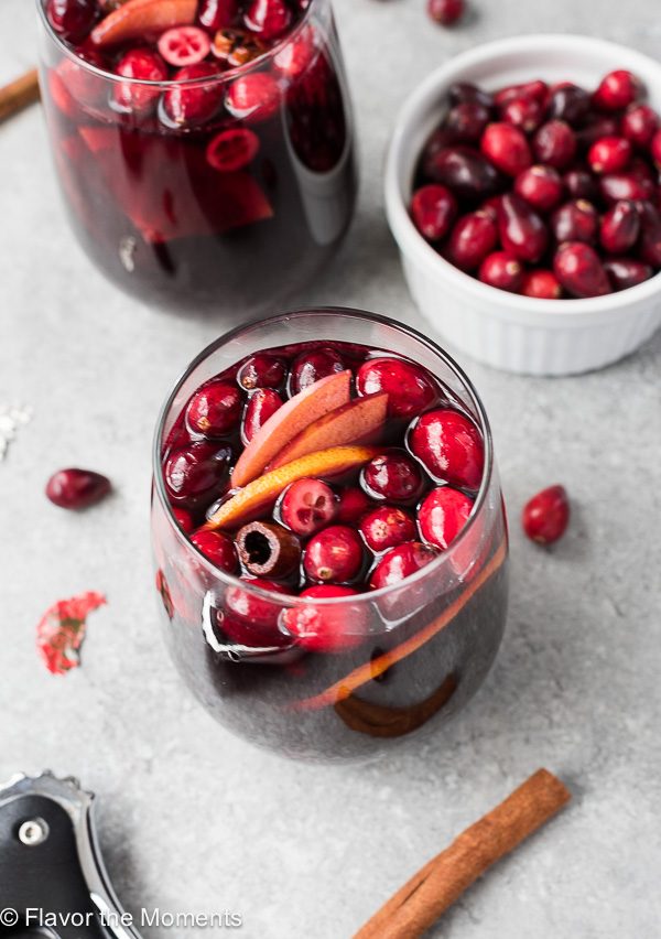 Glass of cranberry sangria with fresh cranberries, apples and cinnamon