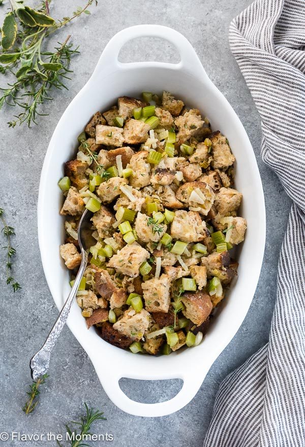 Slow cooker stuffing in a white serving bowl with spoon