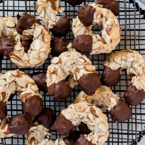 Chocolate dipped almond horn cookies on wire rack
