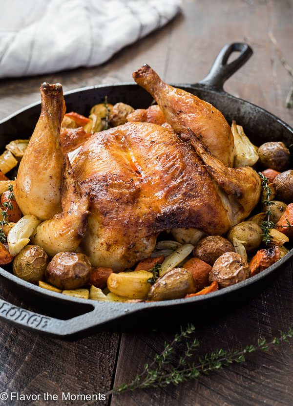 Roasted spatchcock chicken in skillet with potatoes, fennel and carrots