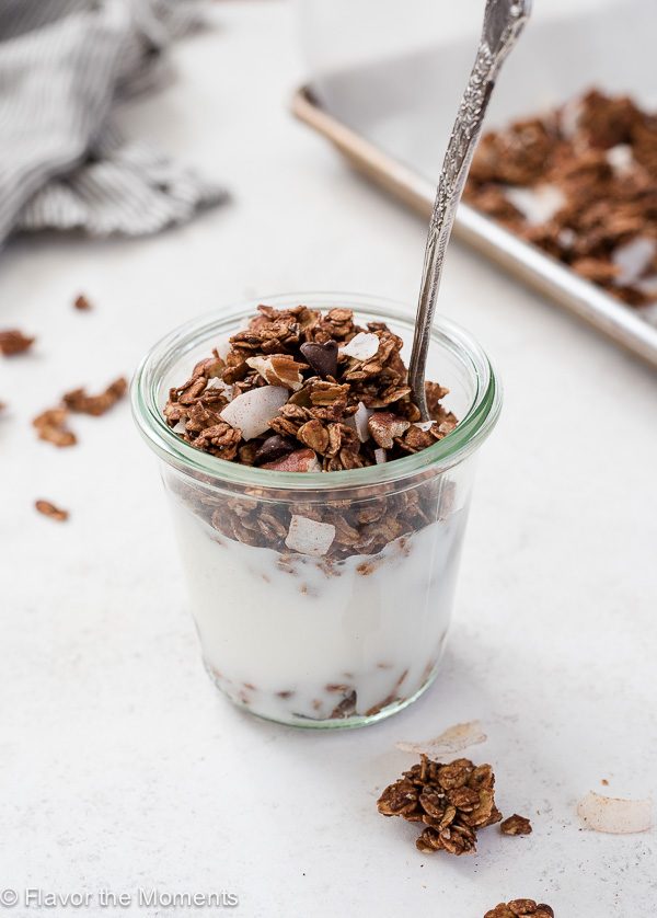 Jar of yogurt with german chocolate granola on top and spoon