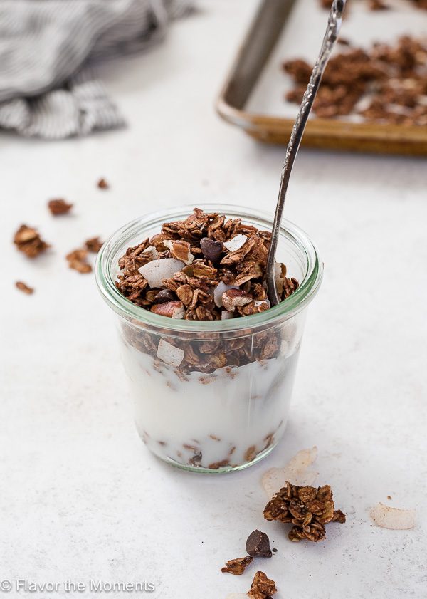 Jar of yogurt with german chocolate granola and a spoon