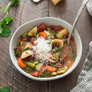 Bowl of Instant pot vegetarian minestrone soup with spoon and parmesan