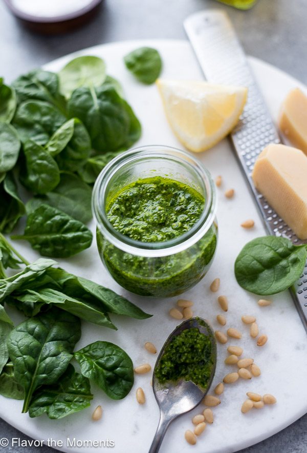 Homemade pesto sauce in jar with spinach, pine nuts and parmesan