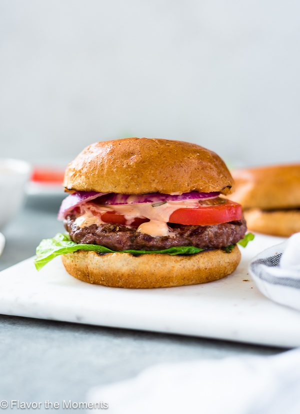 A classic grilled burger on a white plate. 