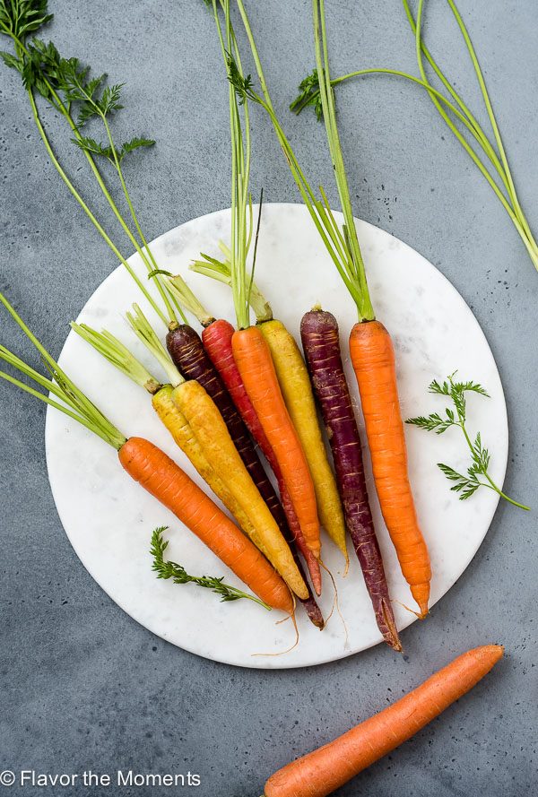 Carrots on a white marble board for carrot produce guide