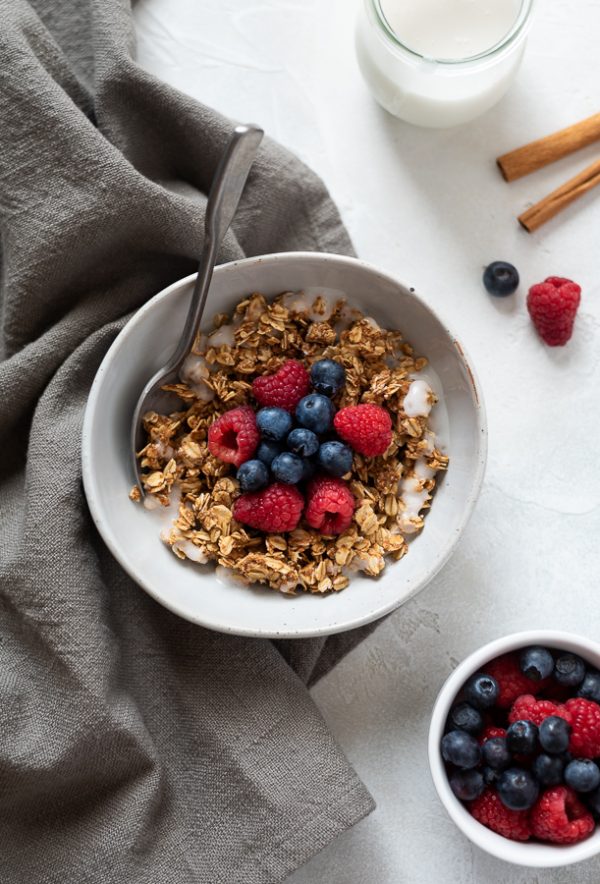 overhead shot of almond butter granola in bowl topped with berries