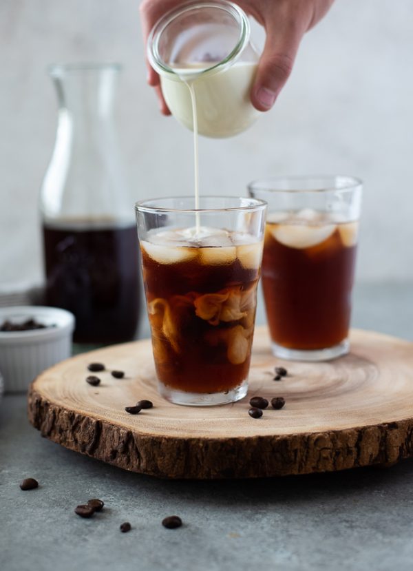 cold brew coffee recipe in glass with creamer pouring