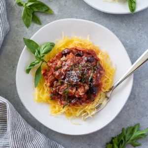 keto spaghetti squash on white plate with basil and fork