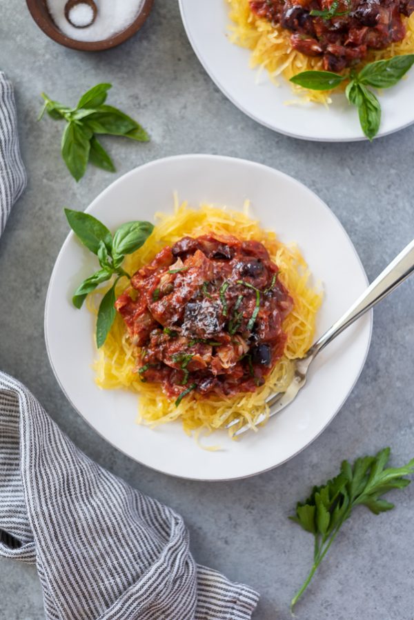 overhead shot of keto mediterranean spaghetti on white plate with basil