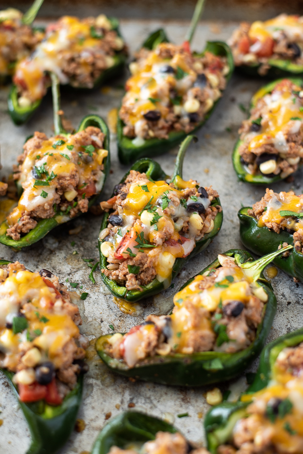 Stuffed poblano peppers on a sheet pan with cheese and cilantro