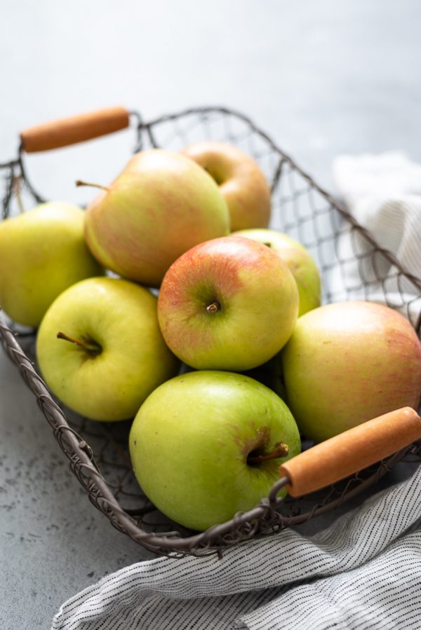 close up of apples in a wire basket