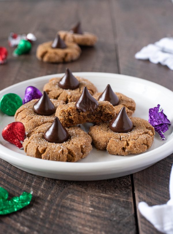 gluten free peanut butter blossoms on a white plate with bite out of top cookie
