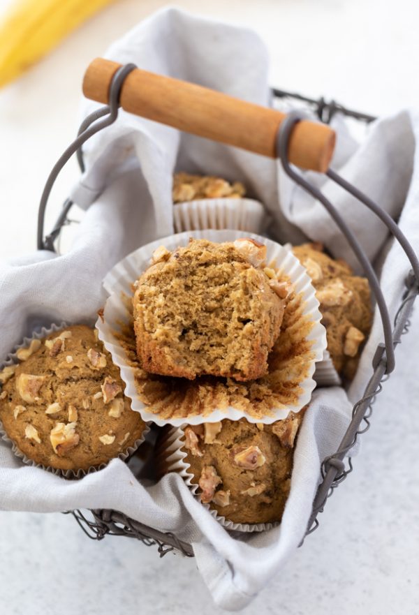 Healthy banana muffins in basket with bite out of top muffin