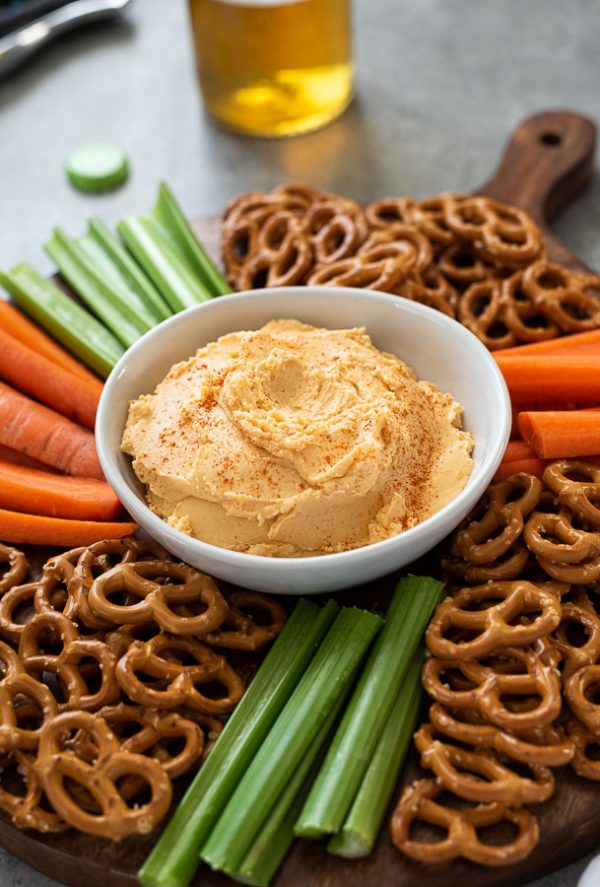 close up of pub cheese recipe with pretzels, carrots and celery surrounding