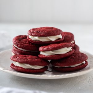 Red velvet cookies piled high on a white plate
