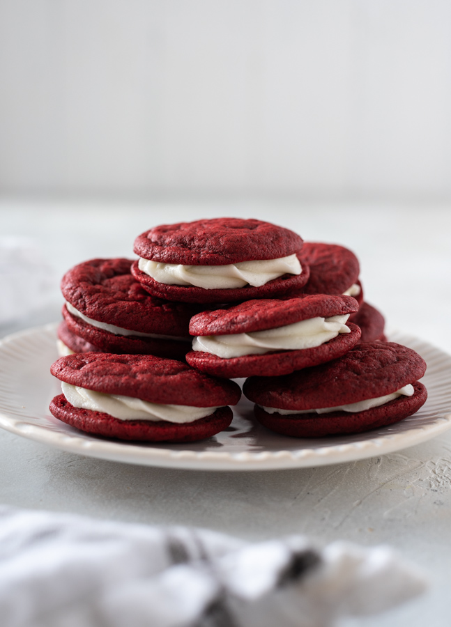 Red velvet cookies piled high on a white plate