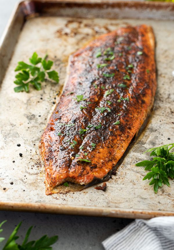 broiled salmon on baking sheet with chopped parsley on top