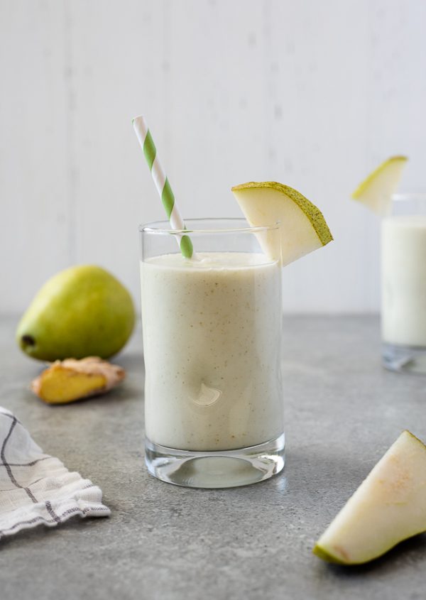 close up of pear smoothie with pear and ginger in the background