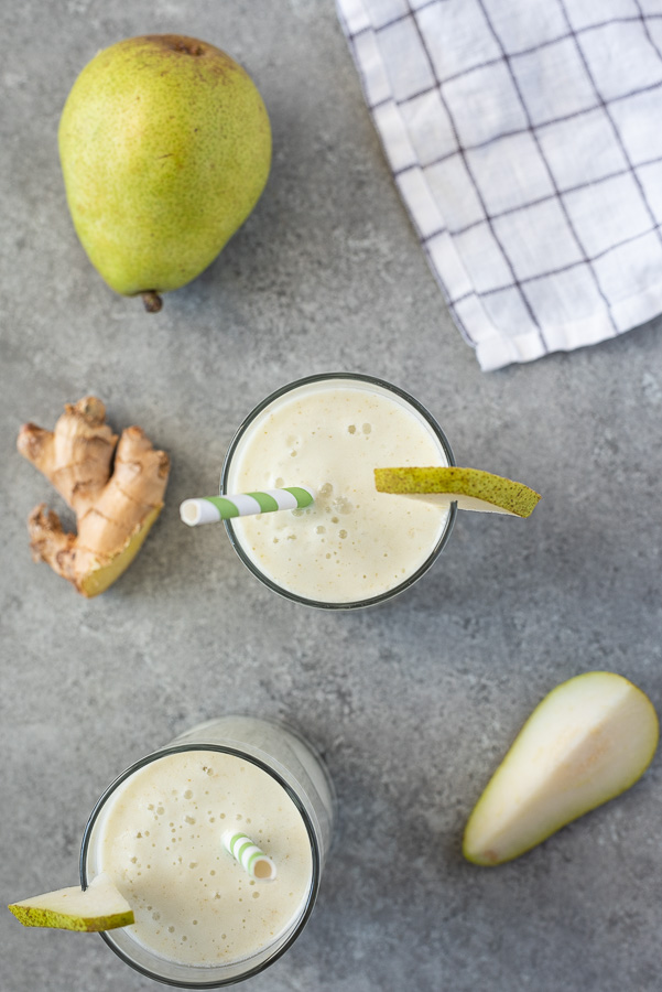 overhead shot of pear smoothie recipe with straw and slice of pear