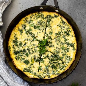 overhead shot of spinach feta frittata sliced in cast iron skillet