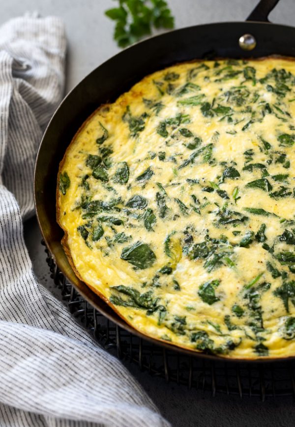 close up of unsliced baked spinach feta frittata