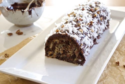 German chocolate roll cake on a white serving plate