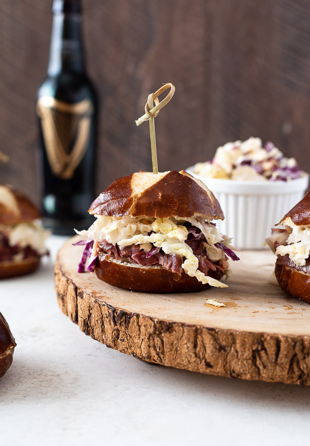 Guinness corned beef sliders with wooden pick through top.