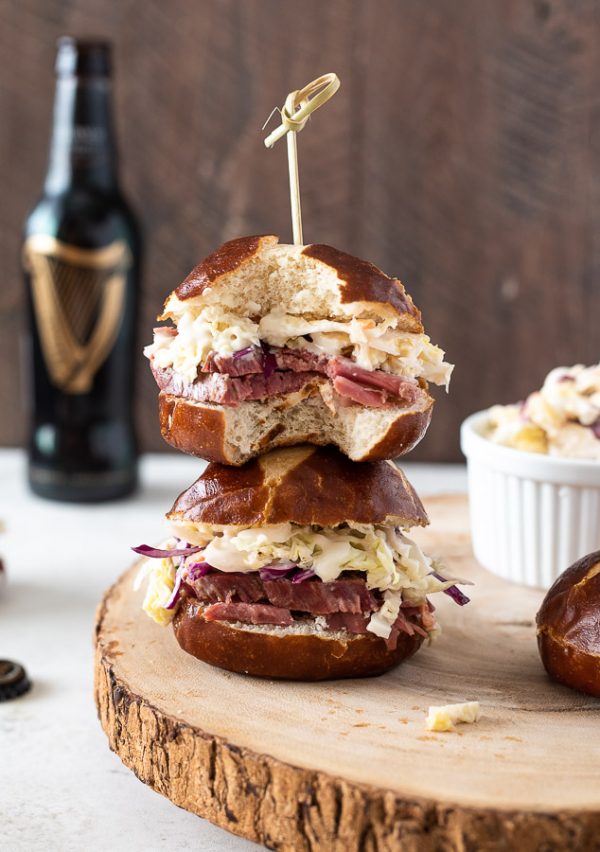 guinness corned beef sliders stacked on top of each other with a bottle of Guinness in background