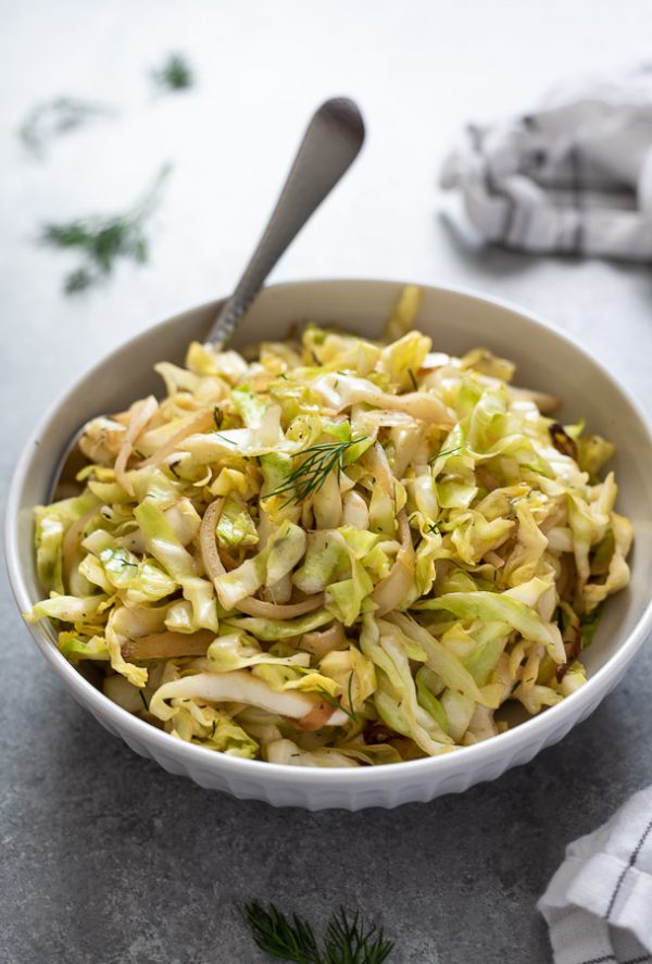 bowl of sautéed cabbage with serving spoon