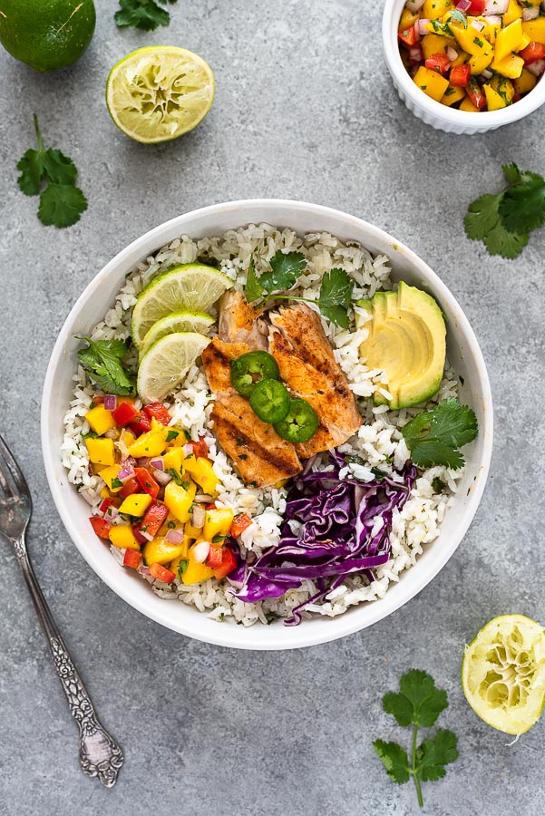 fish taco bowl in white bowl with salsa, cabbage and avocado
