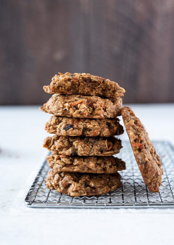 tall stack of healthy carrot oatmeal cookies with one cookie leaning against them
