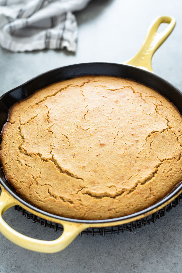 skillet cornbread in cast iron skillet with linen behind
