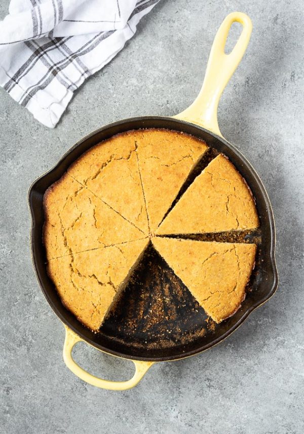 overhead shot of skillet cornbread in cast iron skillet cut into wedges