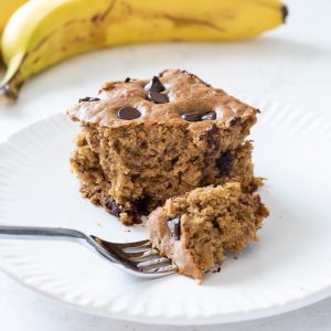 healthy banana cake on a plate with a bite on a fork
