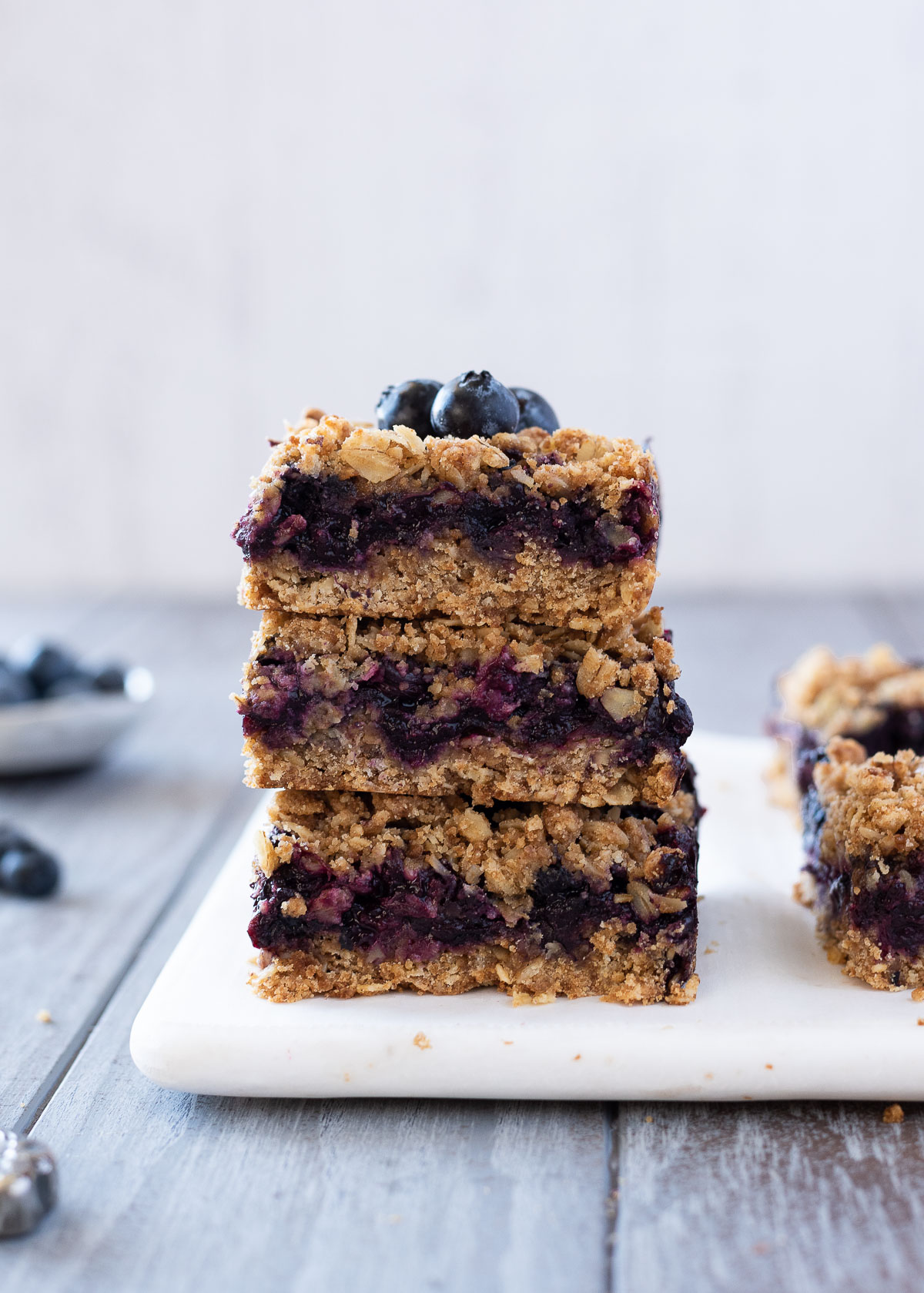 Blueberry crumble bars stacked up with blueberries on top