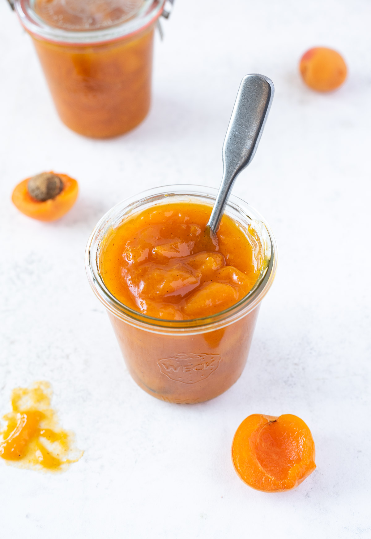 jar of apricot jam with spoon buried into the center