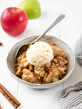 Bowl of apple crisp topped with ice cream