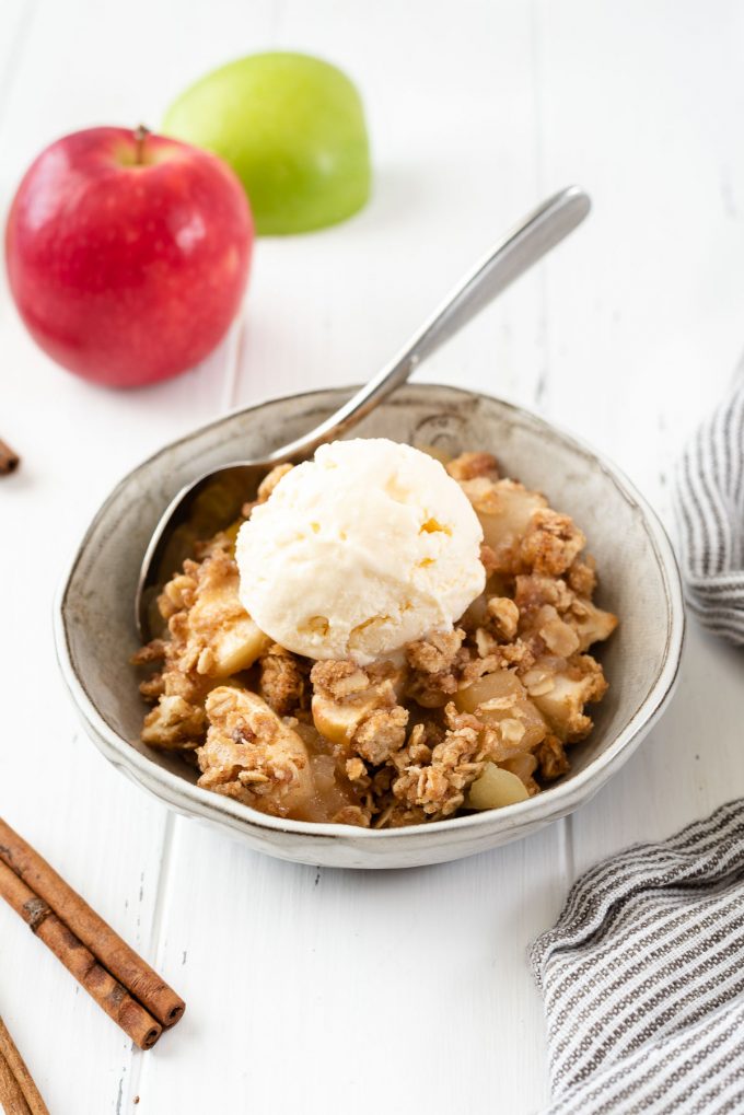 Bowl of apple crisp topped with ice cream