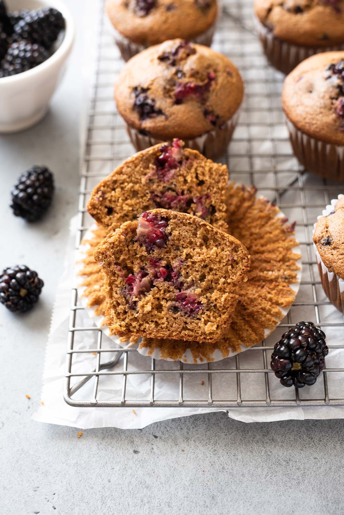 Blackberry muffin cut in half on paper liner