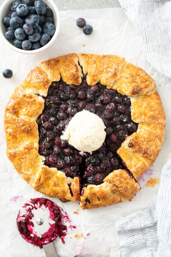 Blueberry galette with scoop of ice cream in center.