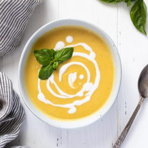 Summer squash soup with swirls of coconut milk and basil on top
