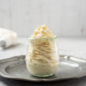 Homemade whipped cream piped in a jar