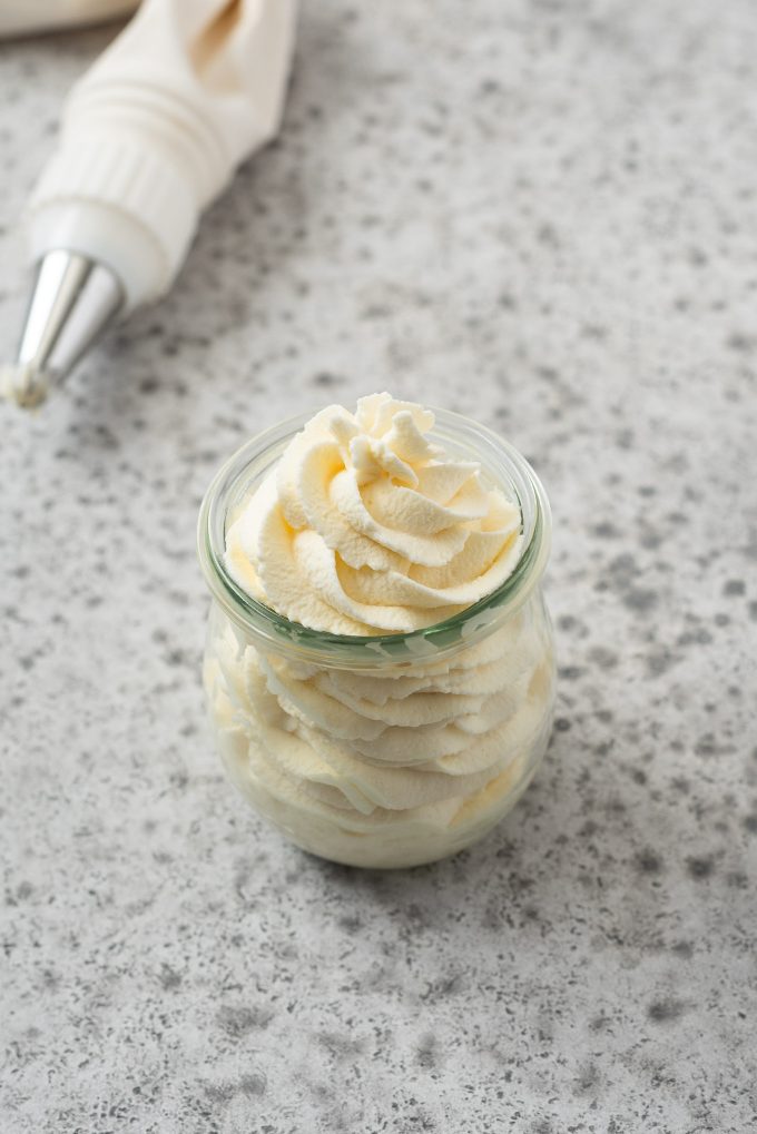 Angled view of jar filled with piped whipped cream