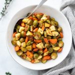 Roasted brussels sprouts and carrots in a bowl with thyme